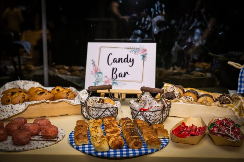 Candy bar de boda con bollería, dulces y chuches junto al cartel “Candy Bar” en el banquete del Restaurante Aura Zaragoza.
